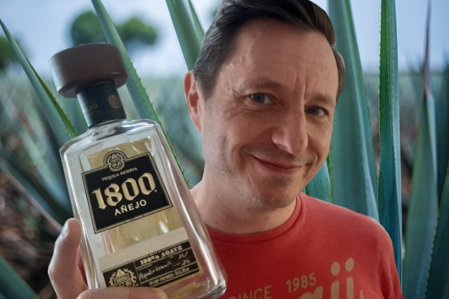 andrew holding bottle of 1800 Tequila Añejo