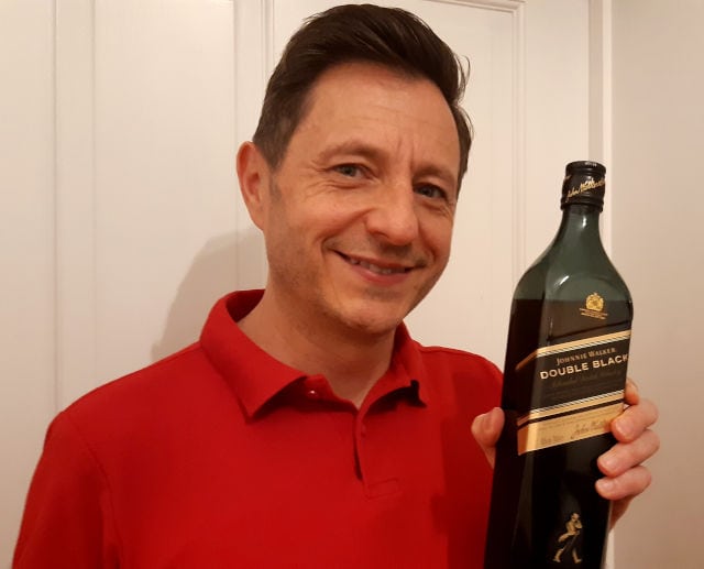 Andrew holding Johnnie Walker double black label whisky