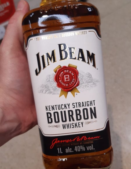 Andrew holding a bottle of Jim Beam Kentucky Straight Bourbon Whiskey