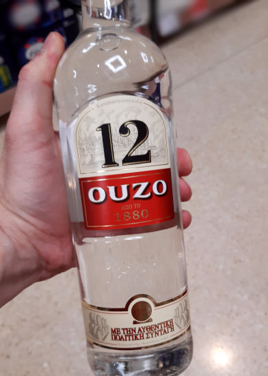 Andrew holding a Bottle of 12 Ouzo