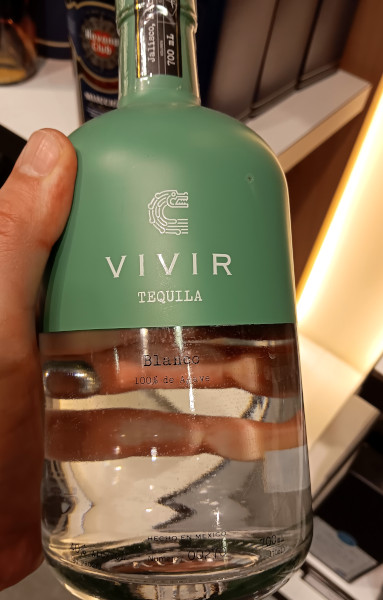 holding bottle of VIVIR blanco.