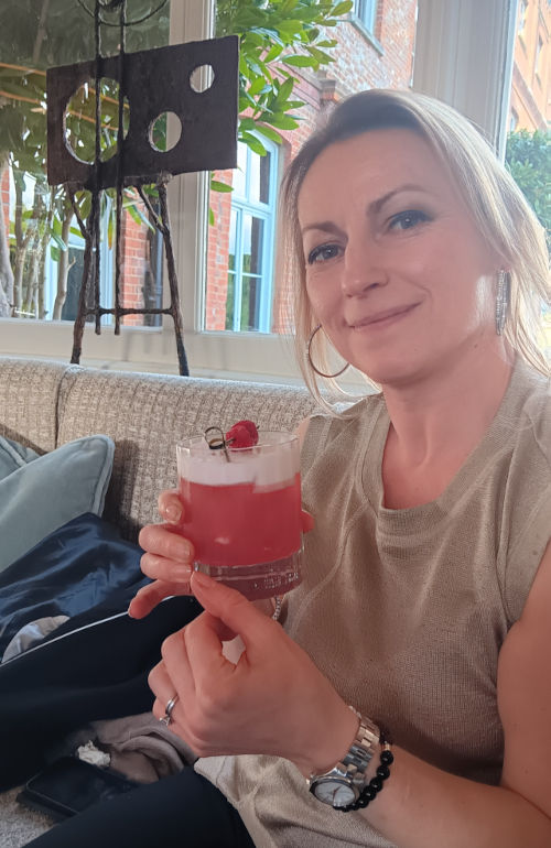Ingrid drinking a pink gin cocktail